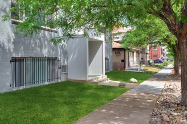 25 Emerson with grey brick construction, classic mid century style, and lush lawns.