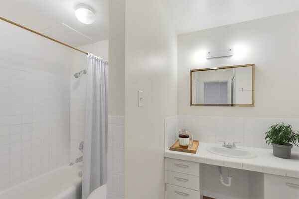 Bathroom with white countertops and white cabinets.