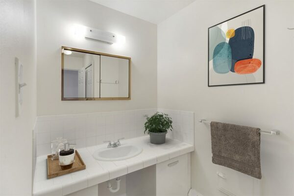 Bathroom with white countertops and white cabinets.