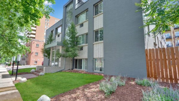 50 Corona apartments with grey brick construction, art deco styling, and rooftop patio.