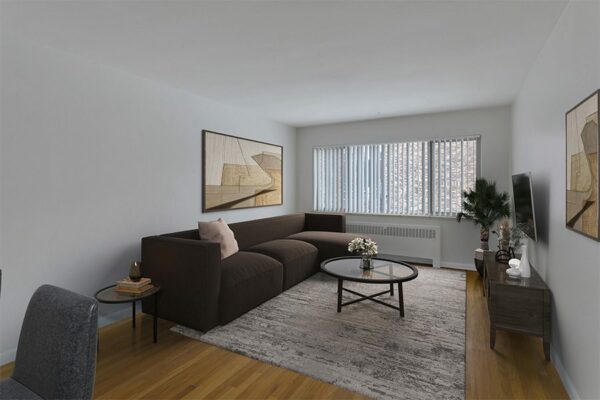 Living room with a carpet over wood floors, white walls, and a large window.