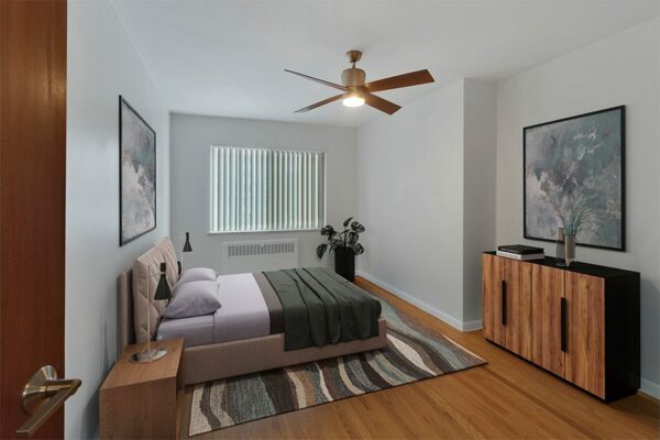 Bedroom with a ceiling fan, carpet over wood floors, and a large window.
