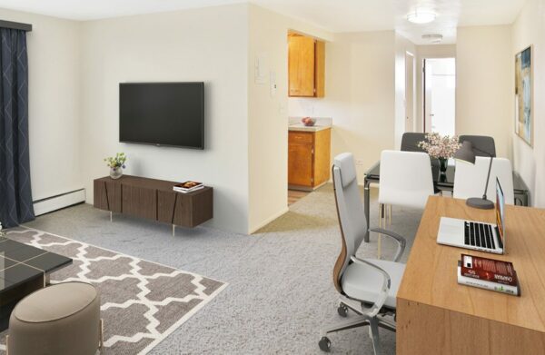 Rendering of a living area connecting to a dining room with carpet and white walls.