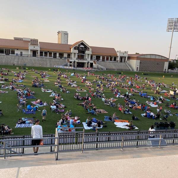 Sports field with people laying on blankets.