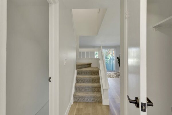 Hallway with a closet door and stairwell.