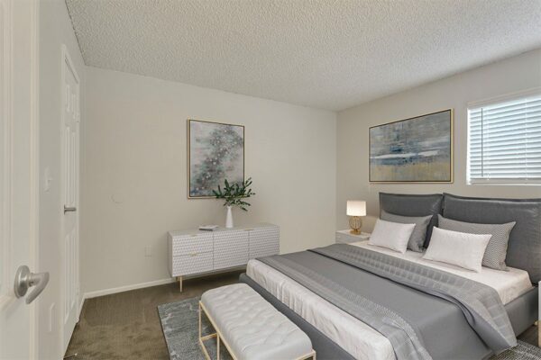 Rendering of a bedroom with tan carpet, white walls, and a window.