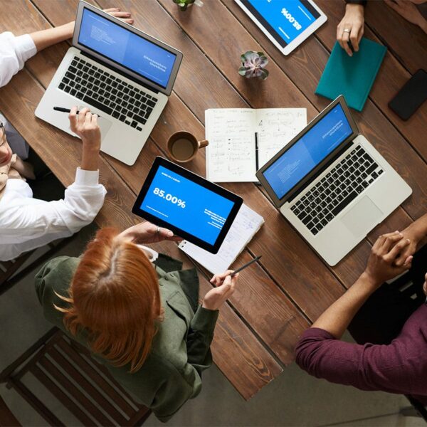 People working together on laptop computers at table.
