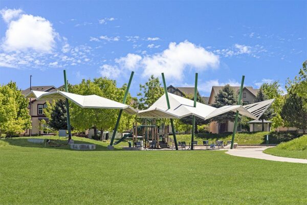 Modern gazebos and playground with lush green lawns in Lowry neighborhood.