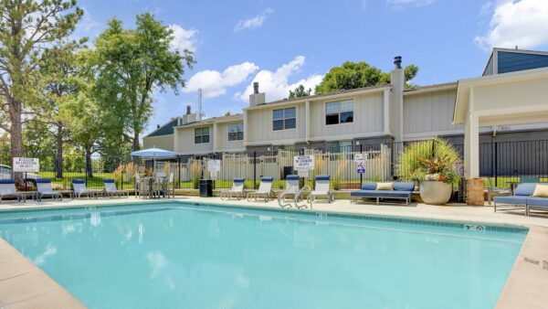 The Pines at Pinehurst pool area with comfortable lounge chairs and shady gazebo.