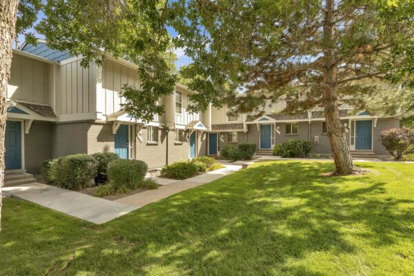 Elowyn townhomes courtyards with lush landscaping, tall trees, and home entrances.
