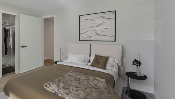 Bedroom with plush bed, framed artwork, and bedside table with decor.