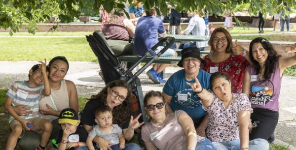 team members sitting on the grass at a company picnic event