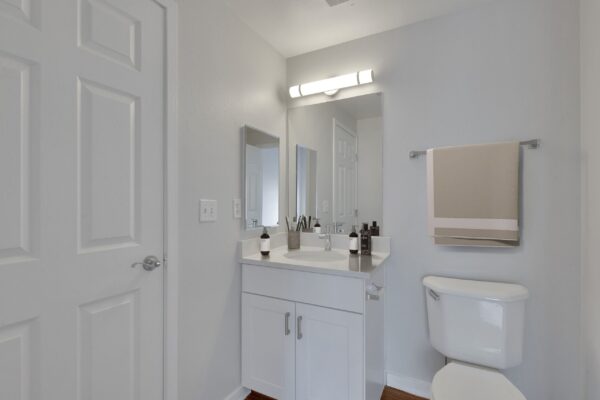 bathroom with white cabinets and storage closet