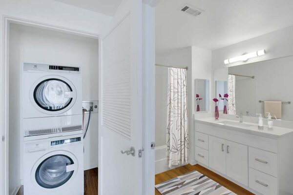 Trocadero apartment bathroom and laundry closet with washer and dryer.