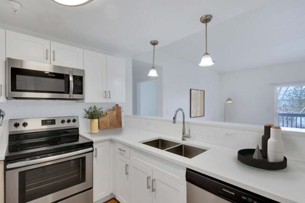 Trocadero apartment kitchen with white cabinets and counters and stainless steel appliances.