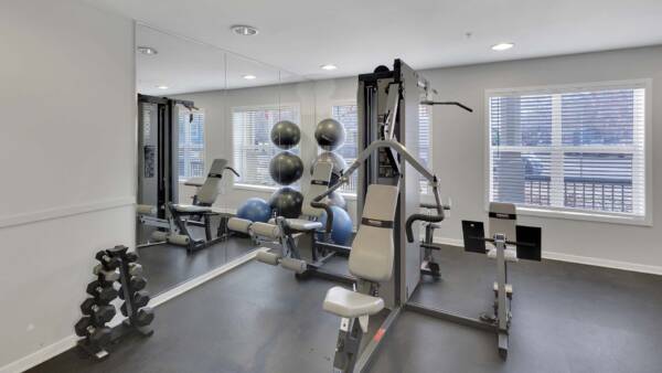 Trocadero apartments fitness center with weight equipment and large windows.