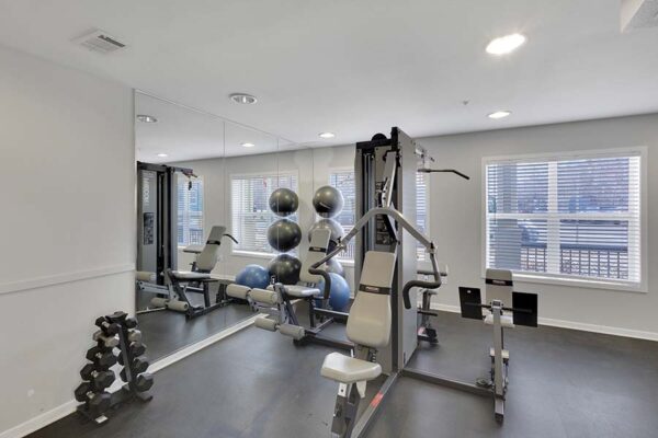 Trocadero apartments fitness center with weight equipment and large windows.