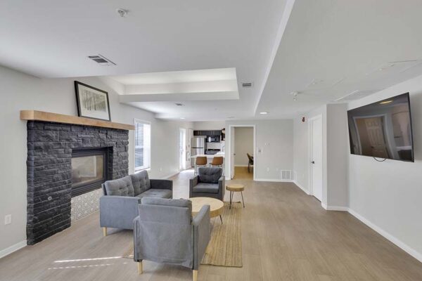 Trocadero apartments lounge with plush seating, fireplace, and wall mounted TV.
