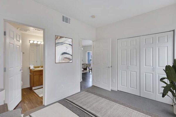 Trocadero apartment bedroom with plush bed, large closet, and door to bathroom.
