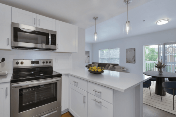 large kitchen with white cabinets and view into living room
