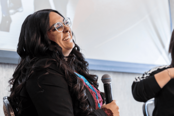 girl laughing while giving a speech at conference