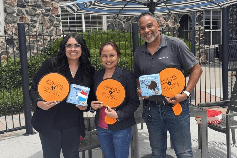 three team members posing with Summer of Love frisbees and ice cream during the summer of love campaign