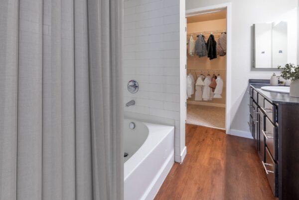 bedroom ensuite bathroom with bath tub and closet