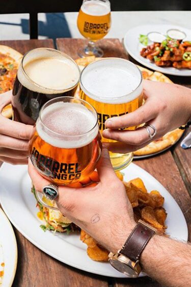 Friends toasting together with glasses of beer.