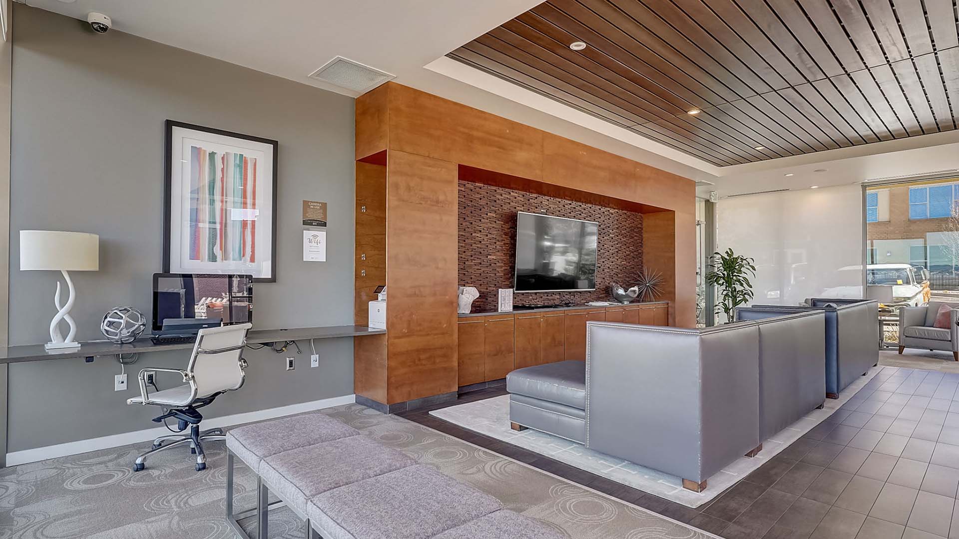 Monaco Row clubhouse with plush seating, large windows, and computer desk.