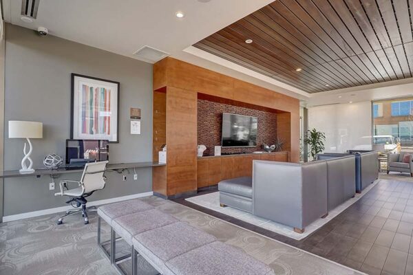 Monaco Row clubhouse with plush seating, large windows, and computer desk.