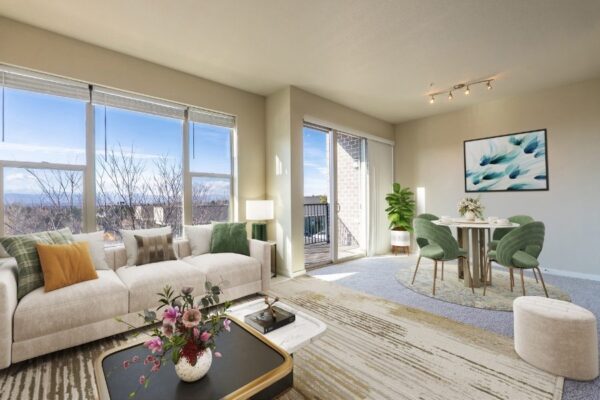 living room with three large windows, couch, coffee table, and dining area
