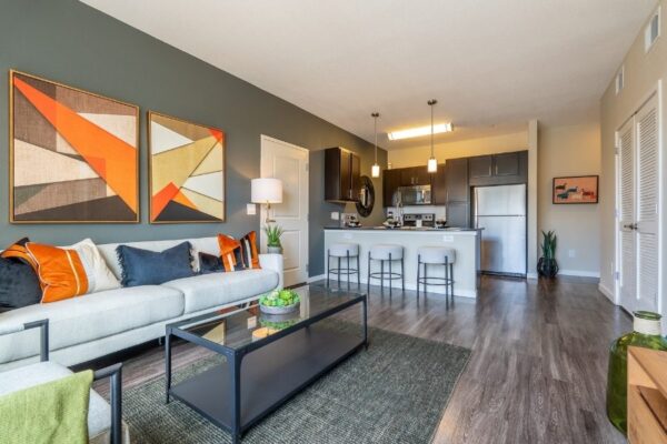 living room with couch, coffee table, and kitchen