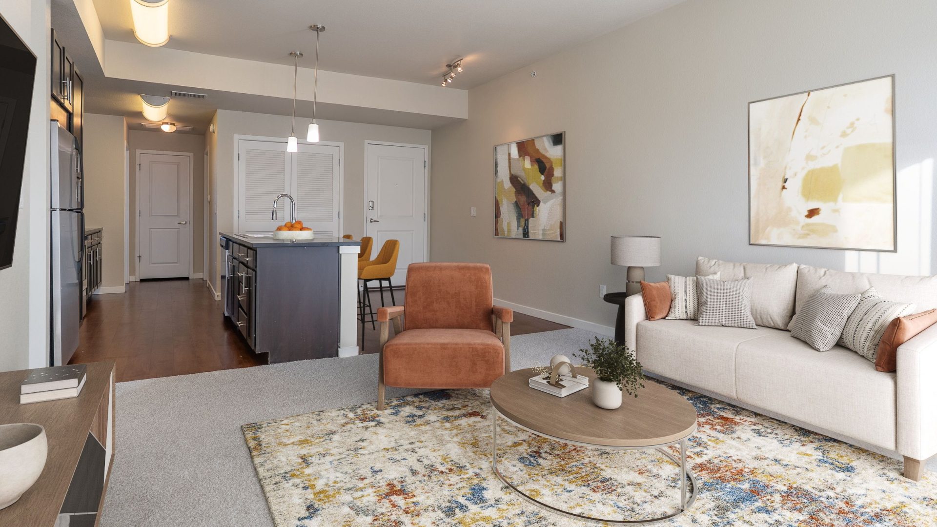 spacious living room with couch and accent chair with view into kitchen