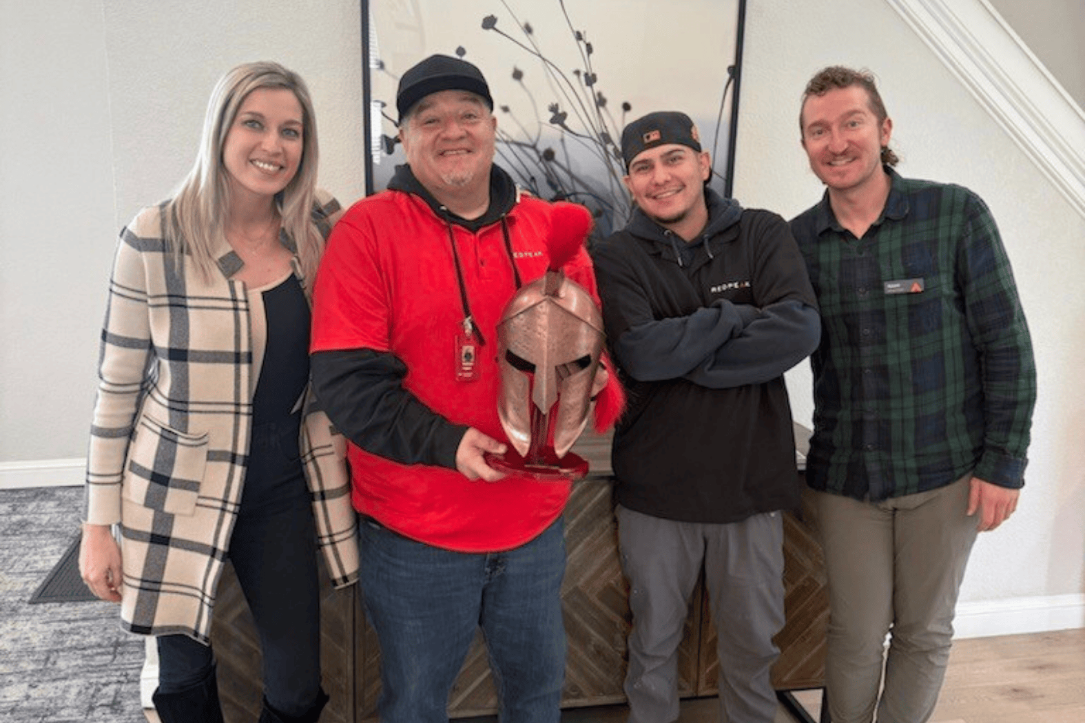 four team members posing with the warrior award won for their exceptional quarter