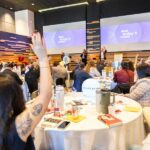 crowd of people raising hands at conference