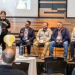 four men sitting on a [panel on stage