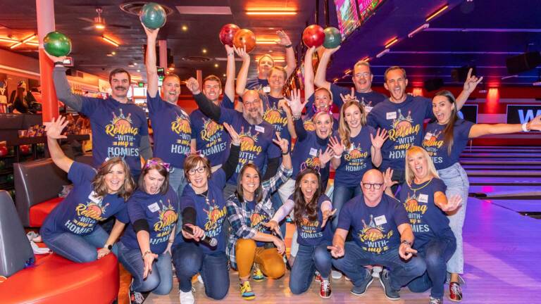 RedPeak team posing together at a team building event at a bowling alley.