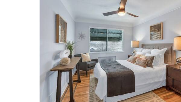 bedroom with large bed, two windows, night stands, and large rug