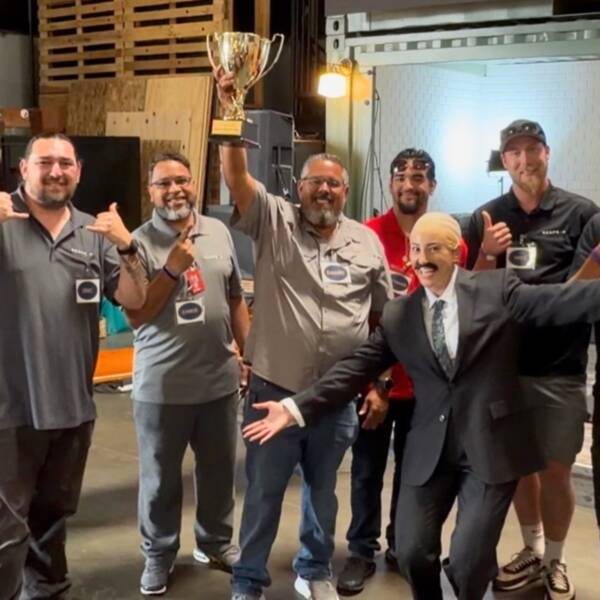 group of mainenance team members holding trophy at team outing