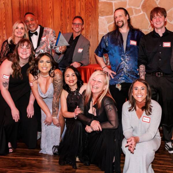 group of people gathered to pose with a trophy