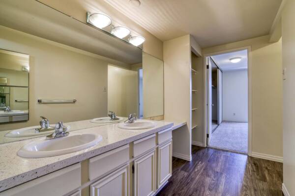 The Manchester apartment bathroom with wood style floor and built in shelves.