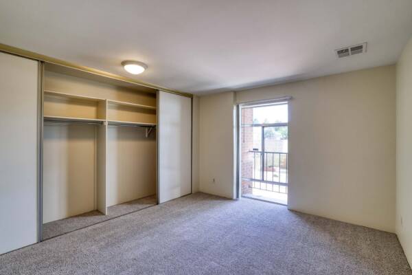 The Manchester apartment bedroom with carpet and large closet.