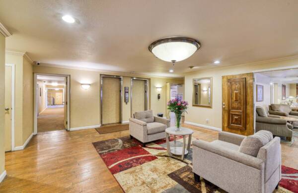 The Manchester community lounge with plush chairs and elevators.